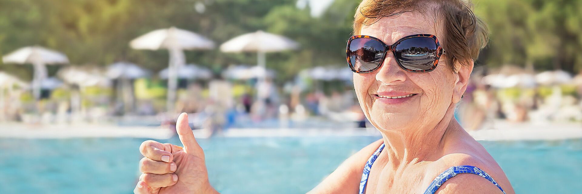 Seniorin mit Sonnenbrille im Freibad