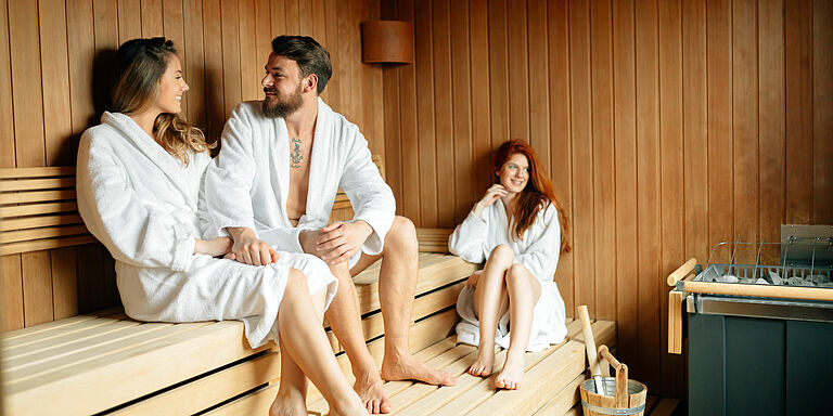 Gruppe mit Bademänteln in der Sauna