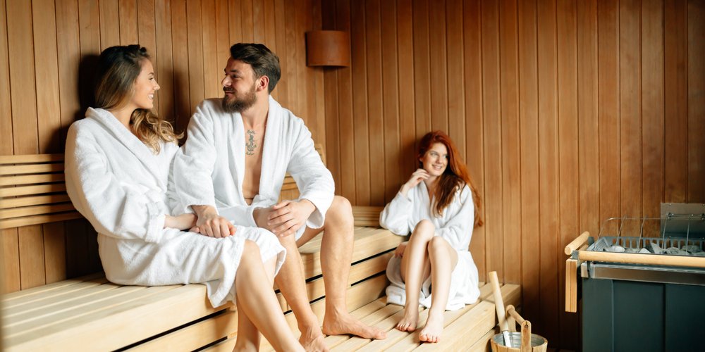 Gruppe mit Bademänteln in der Sauna