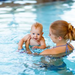 Frau mit Baby im Wasser