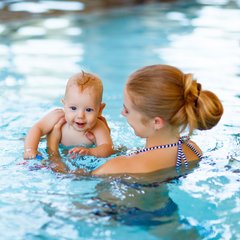 Frau mit Baby im Wasser