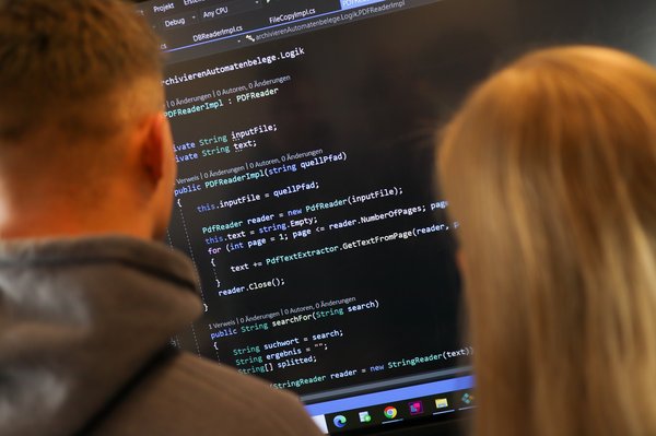 Zwei Personen schauen auf einen Bildschirm