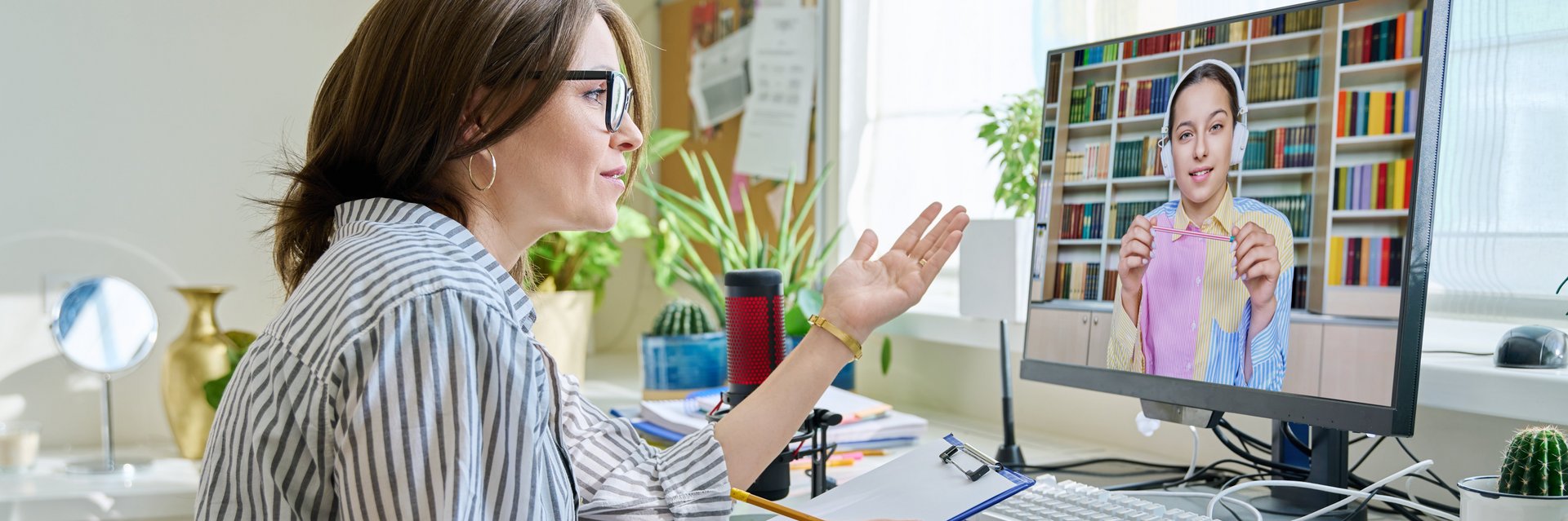 Frau sitzt im Homeoffice und hat einen Videoanrufe auf dem Bildschirm