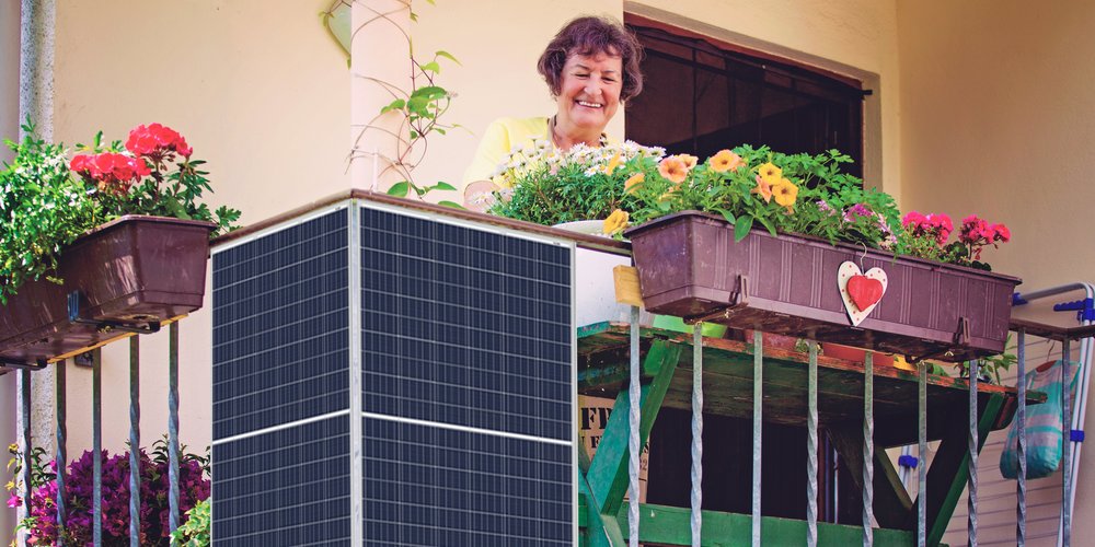 Ältere Dame auf dem Balkon mit Balkonstrom-Anlage und Blumen