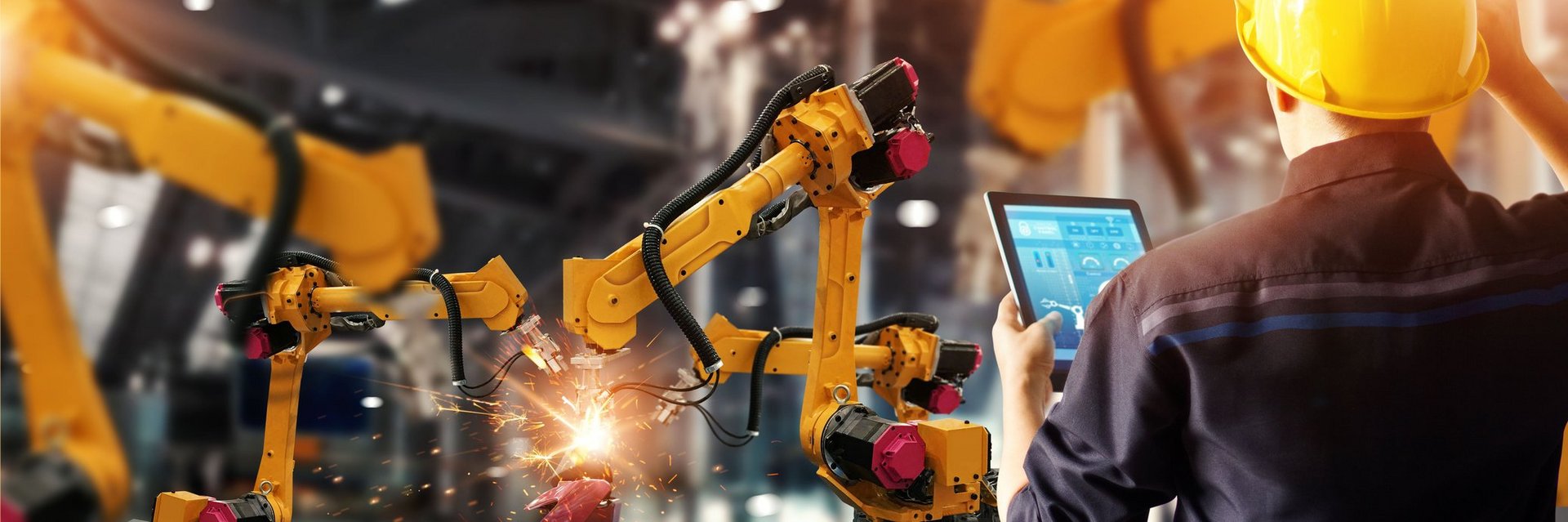 Elektriker testet Roboter Elektriker mit gelbem Helm testet Roboter