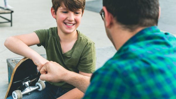 Junge und Mann begrüßen sich freundlich