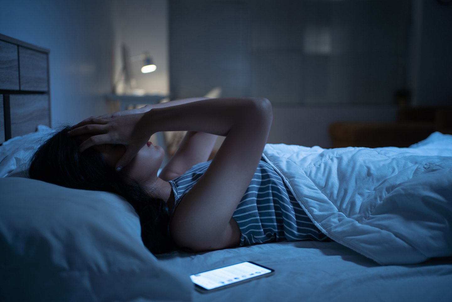 Frau im Bett mit Handy kann nicht schlafen Frau im Bett mit Handy kann nicht schlafen