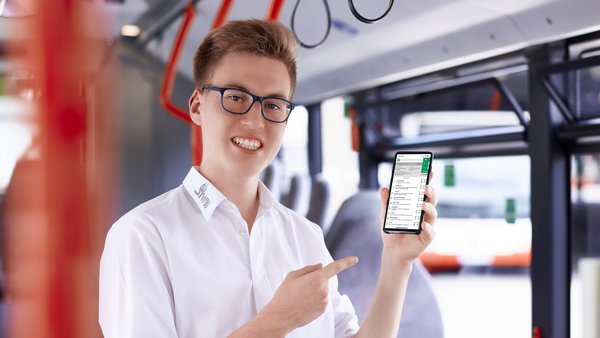 Busfahrer hält Smartphone mit VGN-App hoch