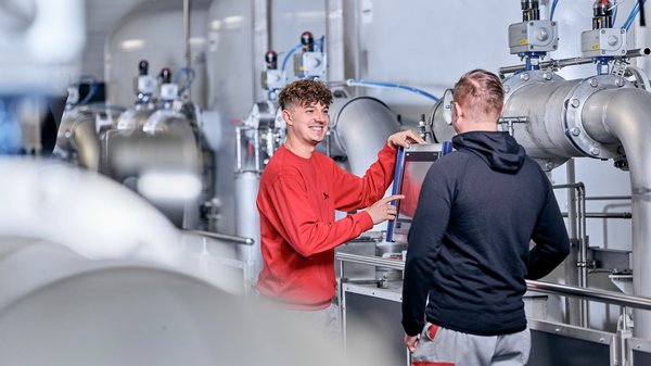 Auszubildender unterhält sich mit Kollegen Auszubildender unterhält sich mit Kollegen