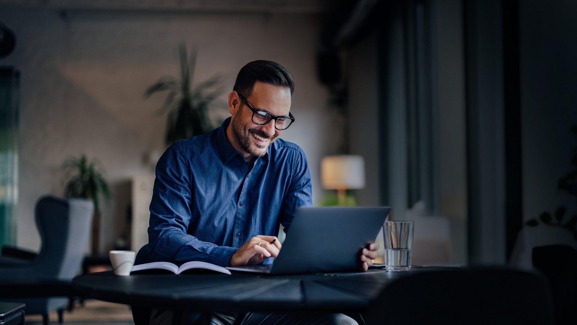 Mann sitzt mit Notebook am Schreibtisch