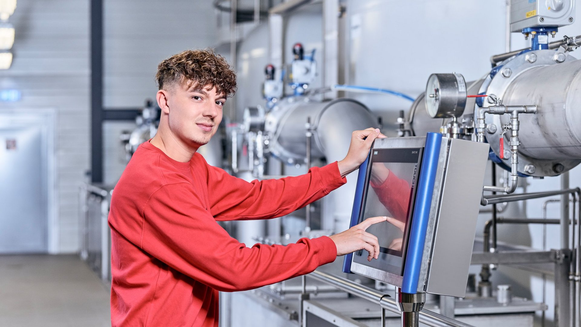 Auszubildender bedient eine technische Anlage im Wasserwerk Auszubildender bedient eine technische Anlage im Wasserwerk