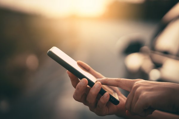 Frauenhand mit Handy in Dämmerung Frauenhand mit Handy in Dämmerung