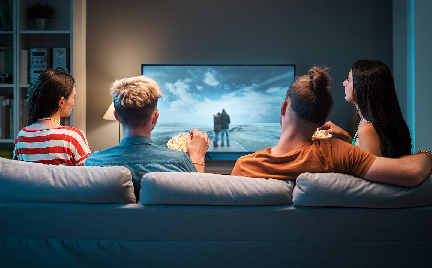 Gruppe junger Menschen schaut am Sofa einen Film