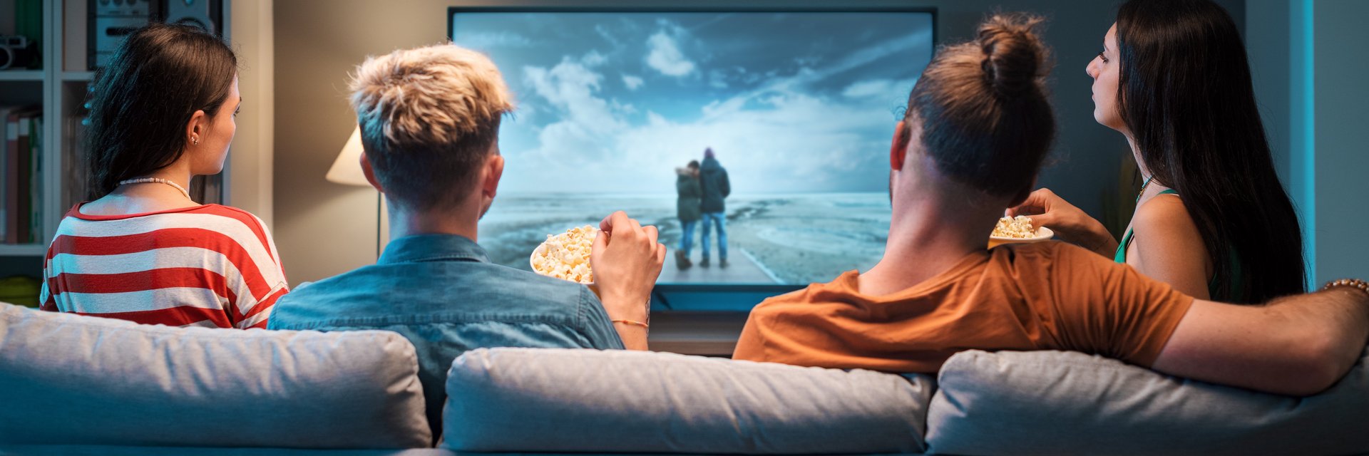 Gruppe junger Menschen schaut am Sofa einen Film