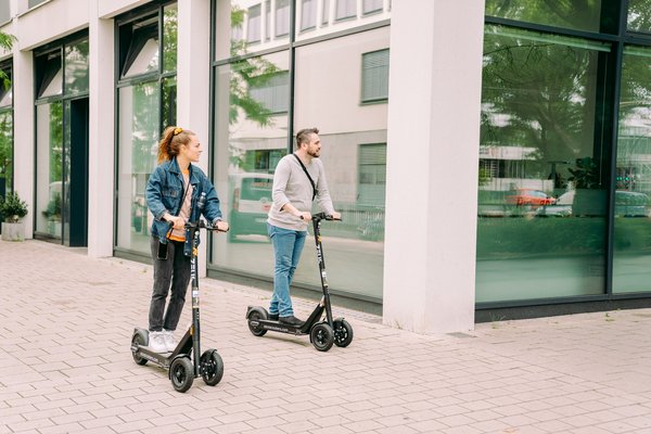 Mann und Frau auf E-Scootern