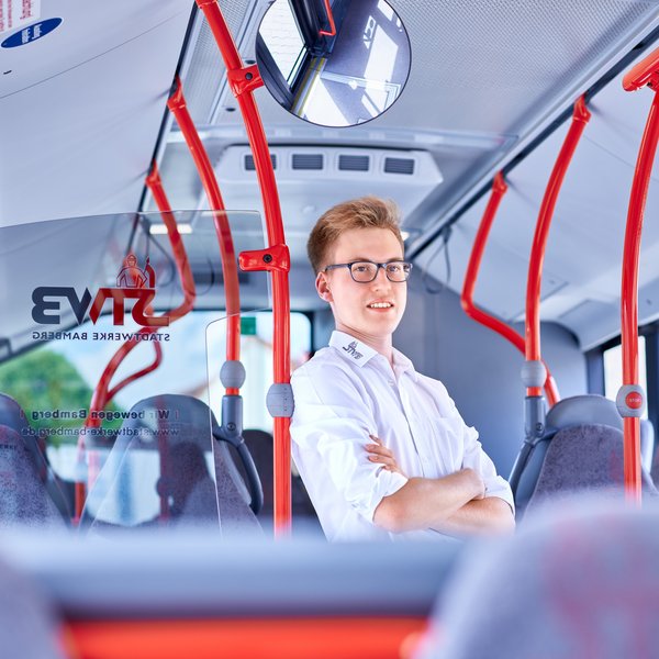 Junger Busfahrer im Fahrgastraum Junger Busfahrer im Fahrgastraum