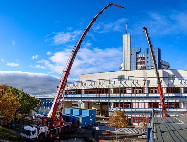 Autokran setzt ein neues Stahlrohr in den Kamin ein