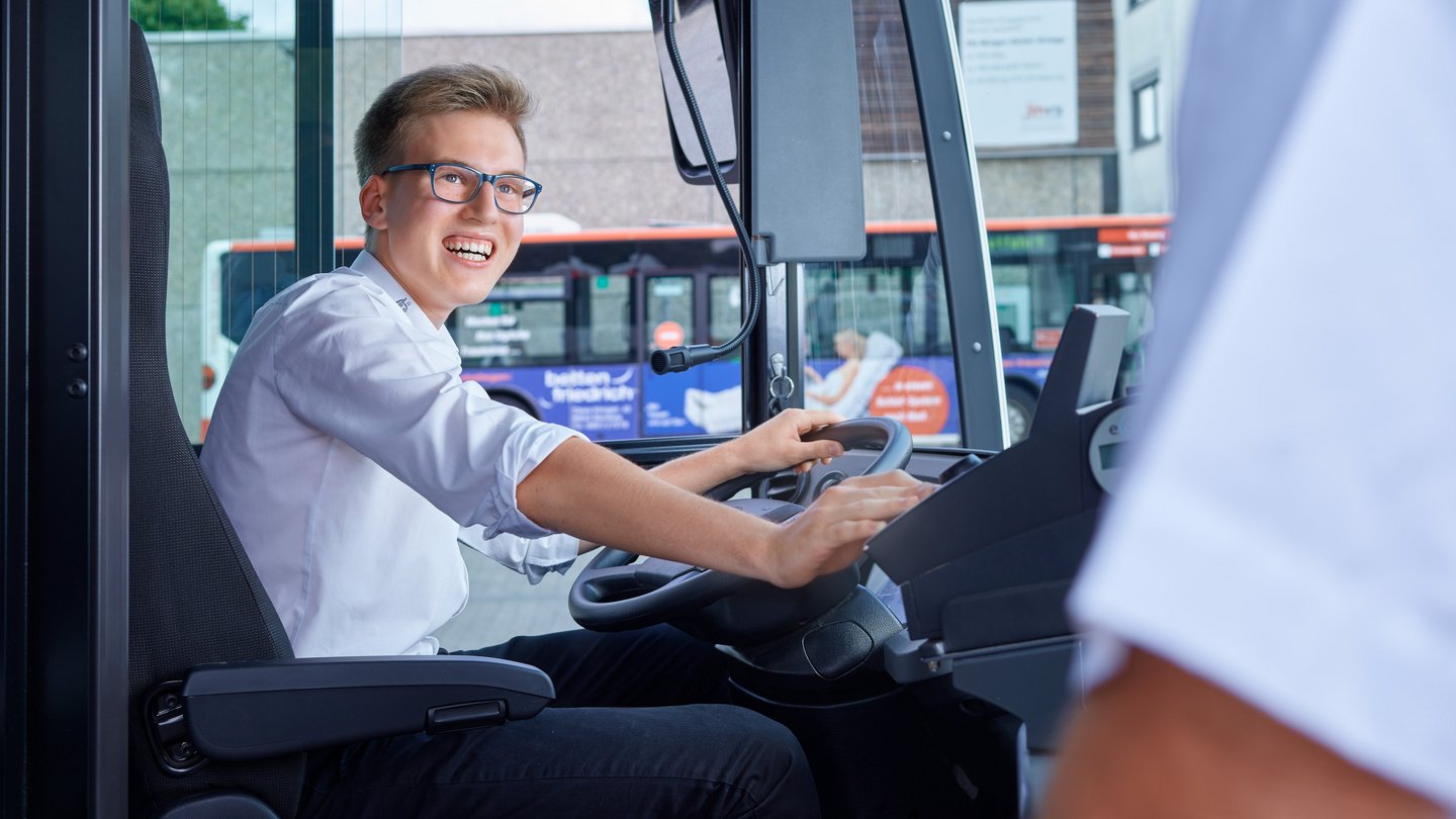 Junger Busfahrer am Fahrersitz Junger Busfahrer am Fahrersitz