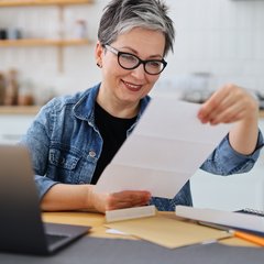 Frau ließt Brief in der Küche