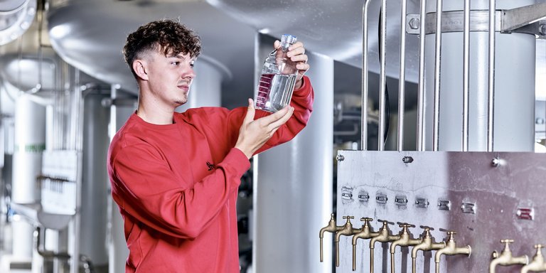 Auszubildender untersucht Wasserprobe Auszubildender untersucht Wasserprobe