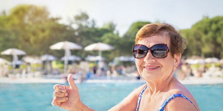 Seniorin mit Sonnenbrille im Freibad