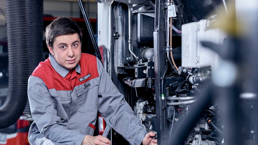 Ausbildung KFZ Mechatroniker- Azubi repariert ein Fahrzeug