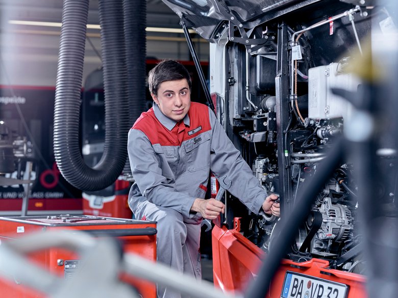 Ausbildung KFZ Mechatroniker- Azubi repariert ein Fahrzeug