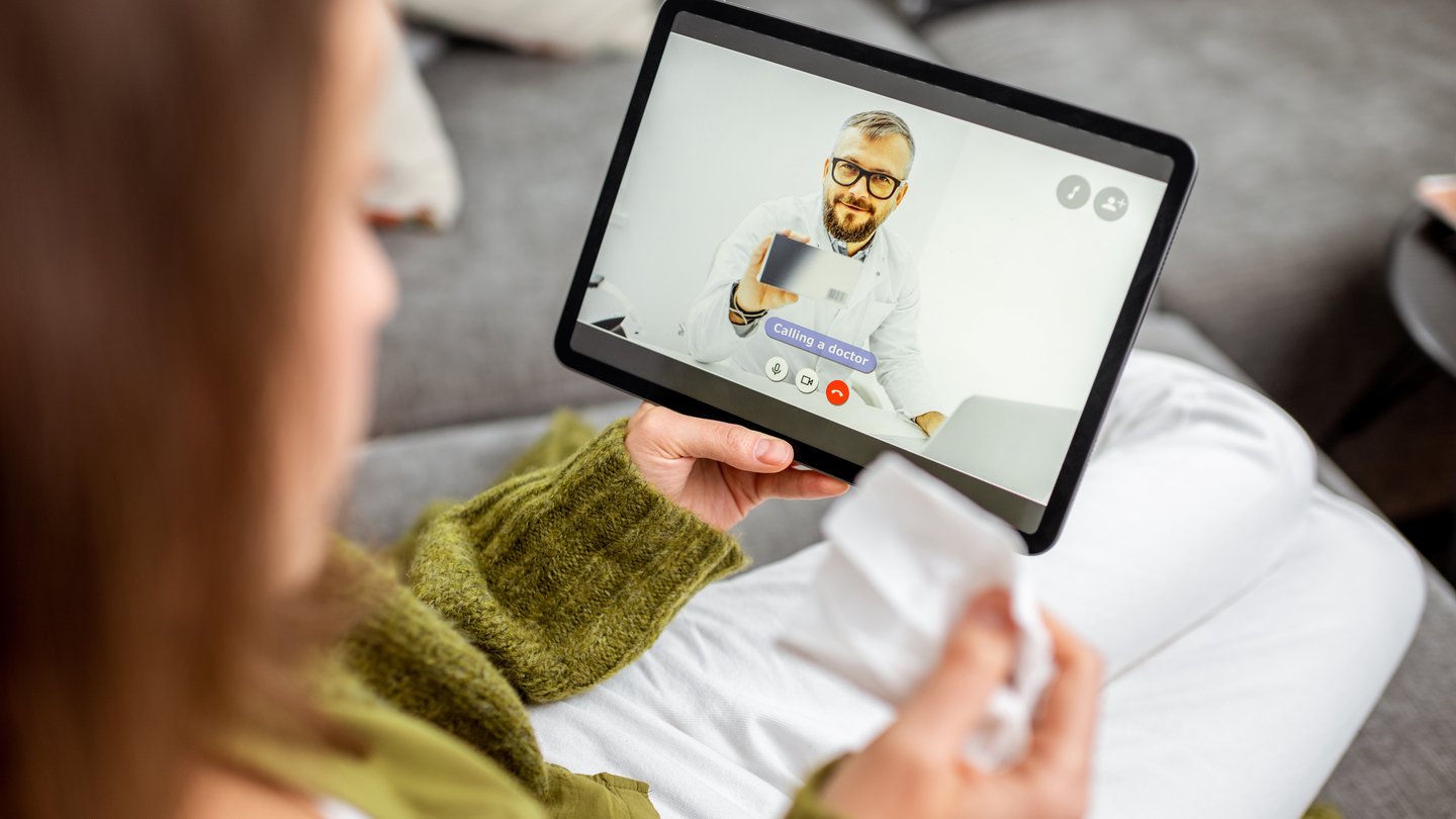 Frau Blick auf Tablet und hat eine Videokonferenz mit einem Arzt Frau Blick auf Tablet und hat eine Videokonferenz mit einem Arzt