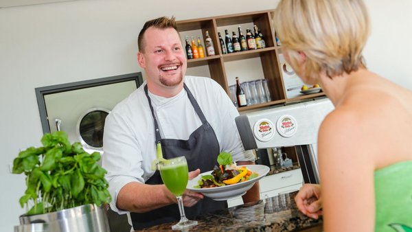 Bambados Gastronomie in der Sauna Mann reicht Frau ein frisches Essen