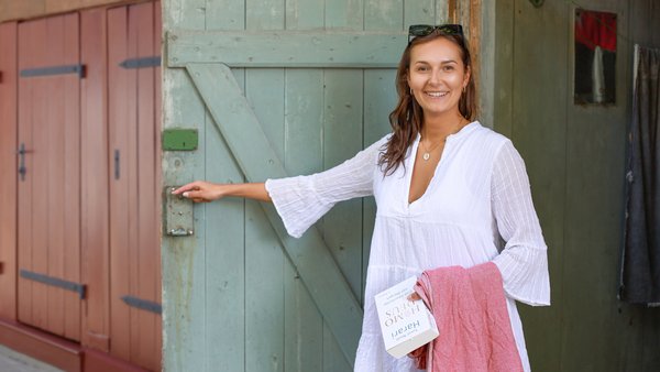 Luisa Hainbadestelle Frau öffnet Holztüre