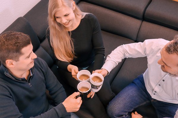 Drei Personen beim Kaffee trinken