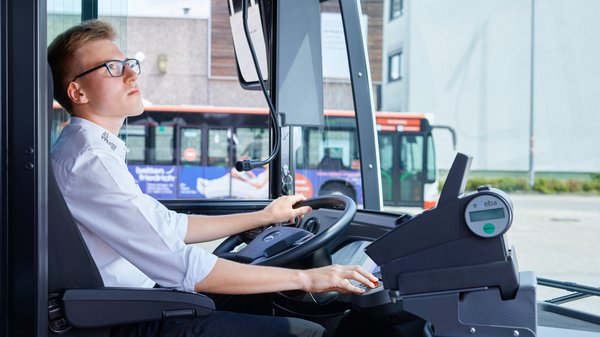Junger Busfahrer am Fahrersitz Junger Busfahrer am Fahrersitz